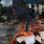 Opositores al gobierno de Nicolás Maduro en Venezuela montan una barricada en las calles de Caracas en una jornada de protesta
