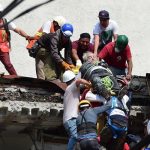 Rescatistas sacan a un hombre de los escombros de un edificio destruido