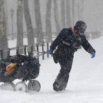 Un cartero tira de su carrito a través de la nieve en Brooklyn, Nueva York.
